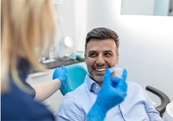 A dentist showing an Invisalign tray to a middle-aged male patient