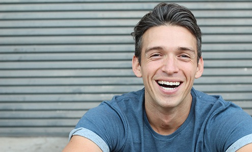 man smiling while sitting outside