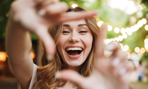 a woman smiling with dental crowns in Fort Mill