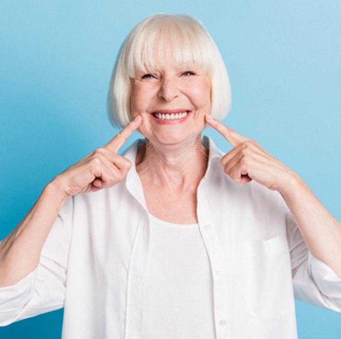 Senior woman pointing to her smile