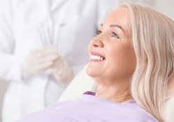 a patient smiling after replacing her missing teeth