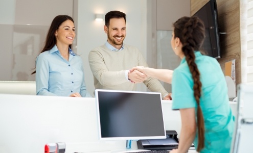 Dental patient checking in at reception desk for emergency dentistry