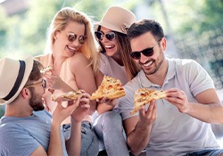 Group of adult friends eating pizza together