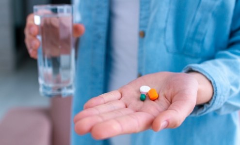 Dental patient holding antibiotic therapy pills