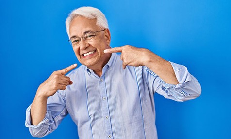 Happy senior man pointing at his smile
