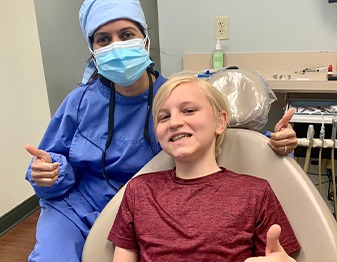 Dentist and young boy patient giving thumbs up in Fort Mill dental office
