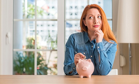 Woman putting coin in piggy bank