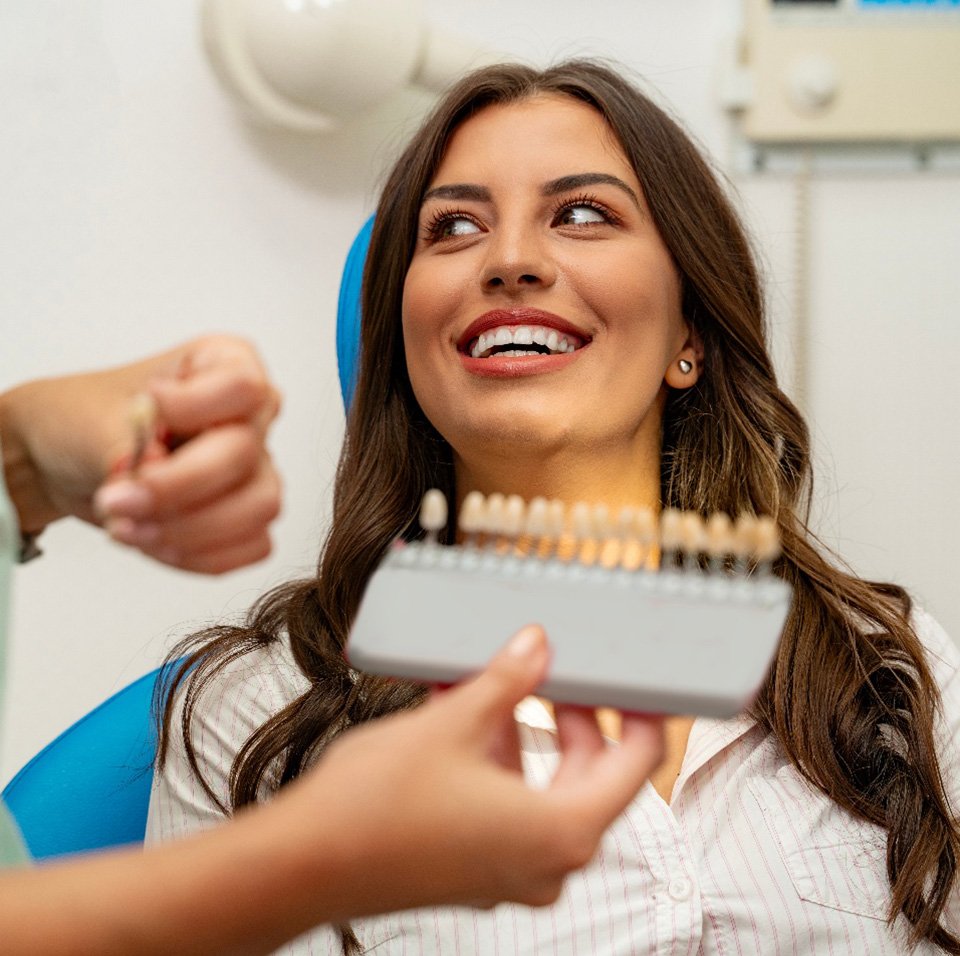 A dentist preparing a woman for a smile makeover
