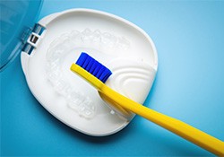 Transparent aligners in a case next to a toothbrush