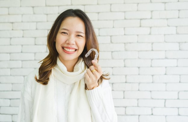 Woman holding her Invisalign aligner.