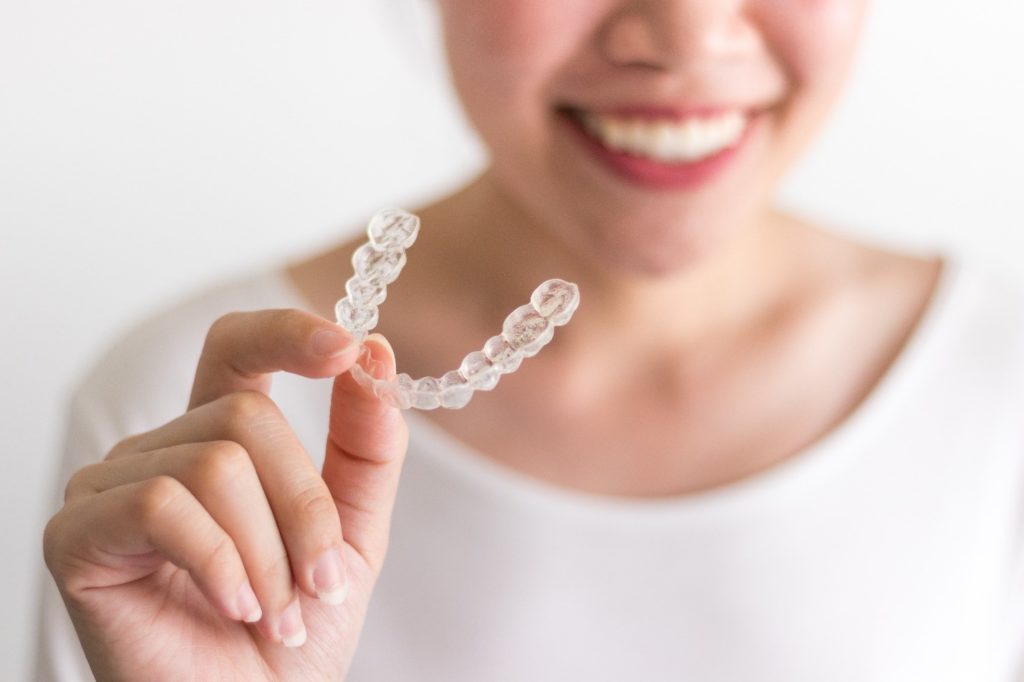 Closeup of patient holding clear aligner