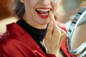 a woman admiring her dental bonding on her teeth