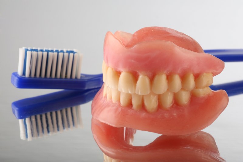 a pair of dentures next to a toothbrush